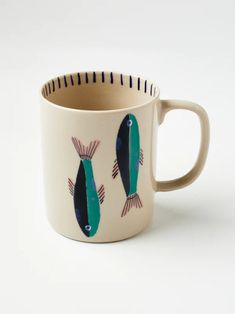 a coffee cup with two fish painted on it