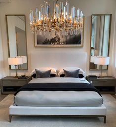 a large bed sitting under a chandelier in a bedroom