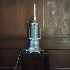 a silver lamp sitting on top of a black table