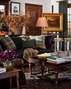 a living room filled with lots of furniture and flowers in vases on the coffee table