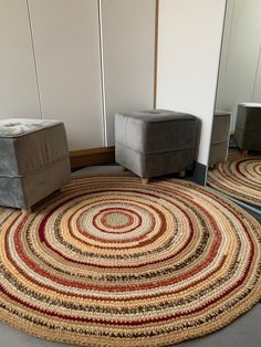 a round rug in the middle of a room with two chairs and a footstool