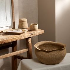 a wooden table topped with a bowl next to a mirror