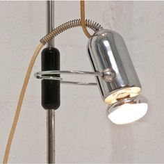 a lamp that is on top of a metal pole with a cord attached to it