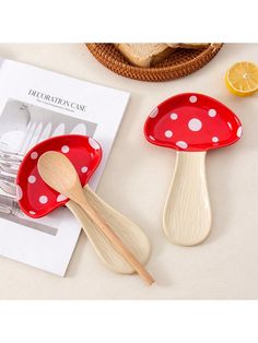 two red and white polka dot spoons sitting on top of a table next to a magazine