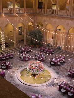 an indoor dining area with tables and chairs set up in the center surrounded by string lights