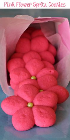 pink flower spritz cookies in a paper bag on a blue surface with text overlay