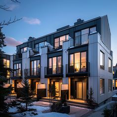 an apartment building with multiple balconies lit up in the evening light at dusk