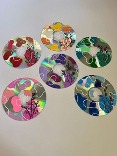 four cds with different designs on them sitting next to each other in front of a white wall