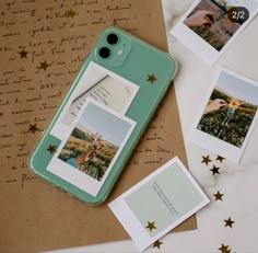 an iphone case sitting on top of a table next to some pictures and papers with gold stars