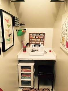 a sewing machine sitting on top of a white table next to a small desk and chair