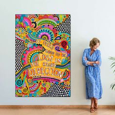 a woman standing in front of a colorful poster