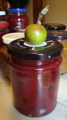 an apple sitting on top of a jar filled with jam