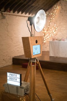 a wooden tripod with a light on top of it next to a projector