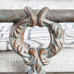 a close up view of a metal handle on a bed with a blue and white pillow in the background