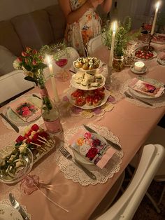 a woman standing in front of a table filled with plates and food on top of it