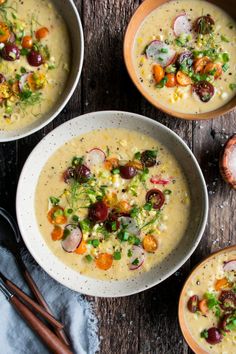 three bowls filled with soup on top of a wooden table