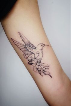 a bird with flowers tattoo on the arm