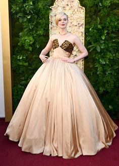 a woman in a dress standing on a red carpet