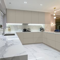 a kitchen with marble counter tops and white cabinets