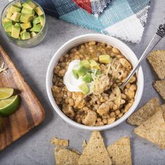 a white bowl filled with beans and avocado next to tortilla chips