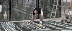 a man standing on top of a rug in the middle of a room next to a ladder