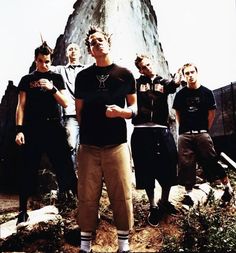 a group of young men standing next to each other in front of a rock formation