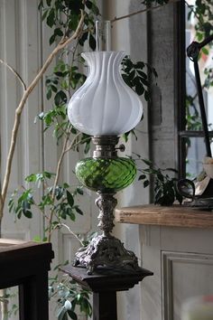 a green and white vase sitting on top of a table