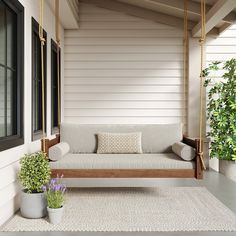 a porch swing with two plants on it