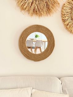 two straw hats hanging on the wall next to a couch and table in a living room