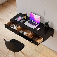 an open laptop computer sitting on top of a wooden desk next to a black chair