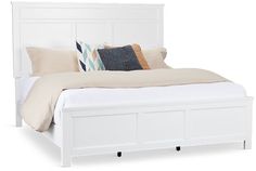 a white bed with two pillows on top of the headboard and night stands next to it