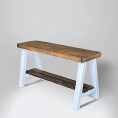 a wooden bench sitting on top of a white table