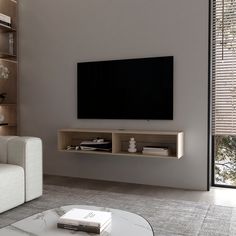 a living room with a large flat screen tv mounted on the wall next to a white couch