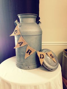 a large metal container sitting on top of a table next to a can and bunting