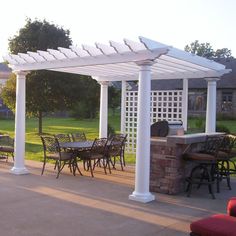 an outdoor dining area with tables and chairs under a white pergoline cover on the patio