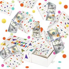 a bunch of money sitting inside of a white box on top of confetti