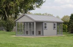 a small gray building in the middle of a field