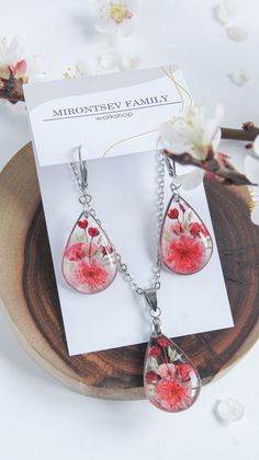 a pair of earrings with flowers on them sitting on top of a piece of paper