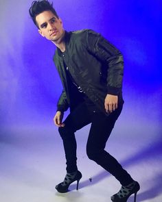 a black and white photo of a man in high heeled shoes posing for the camera