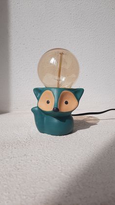 a lamp that is sitting on top of a table with a cat face on it