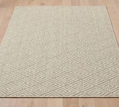 a beige area rug sitting on top of a wooden floor