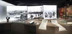 a museum display with several different types of books and papers on the counter, along with other items