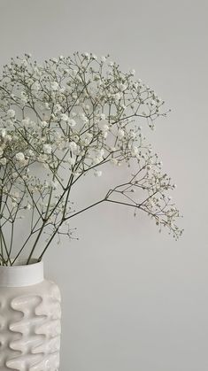 a white vase filled with flowers on top of a table