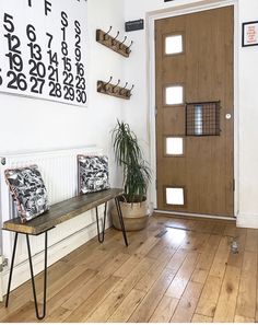 a wooden bench sitting in front of a door on top of a hard wood floor