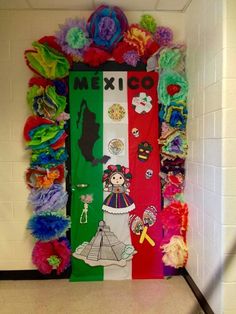 a mexican themed door decorated with colorful feathers and pom poms in the hallway