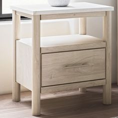 a white vase sitting on top of a wooden table