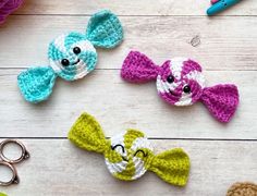 three crocheted bows are sitting on a table next to scissors and other crafting supplies