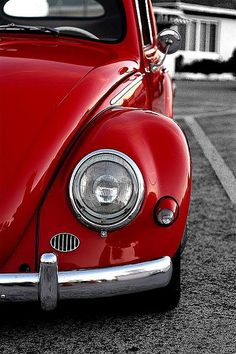 an old red car parked in a parking lot