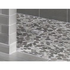 a tile shower with a drain in the middle