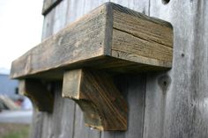 a close up of a piece of wood on the side of a wooden building with nails sticking out of it